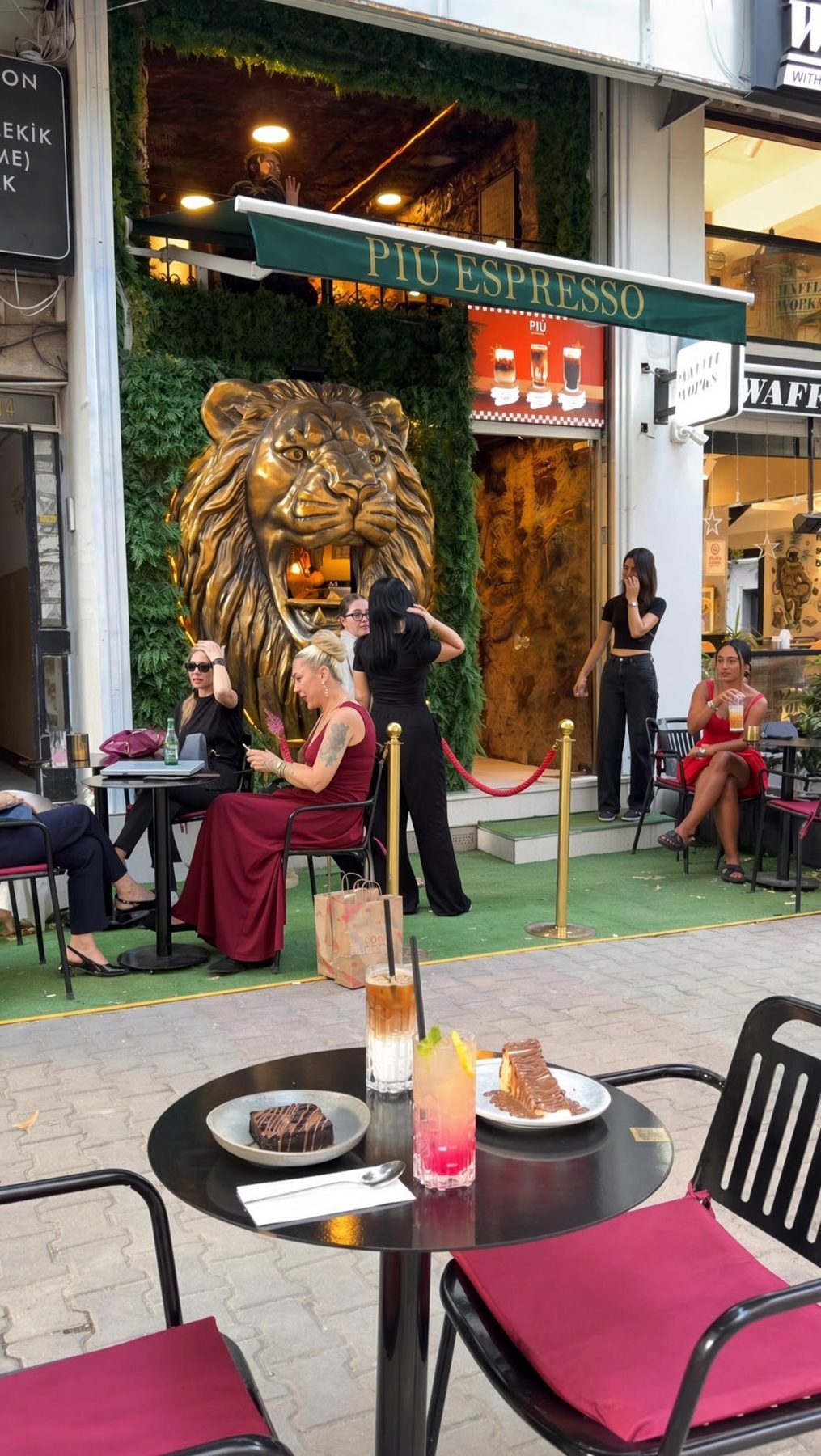 Tables in front of the lion wall at Più Espresso