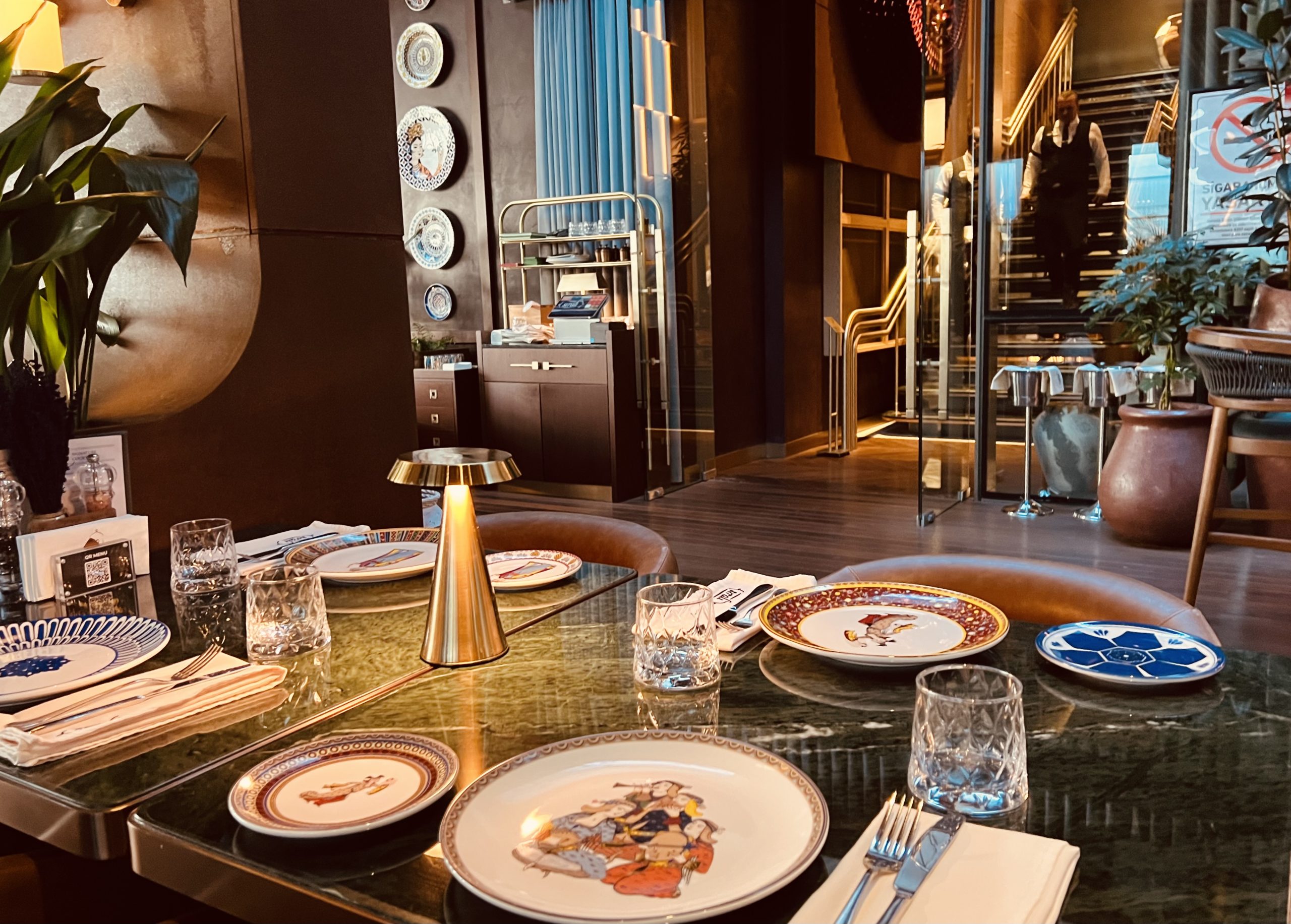 The dining room at Sıralı Kebap Ataşehir, pale chairs and set tables